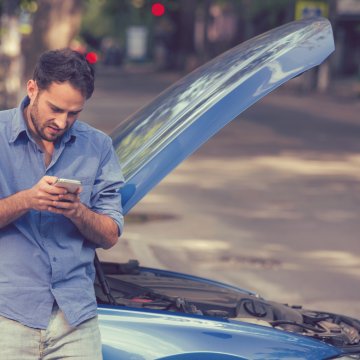 vehicle service contracts extended car warranty axiom moxa man on mobile phone, blue car with open hood car breakdown